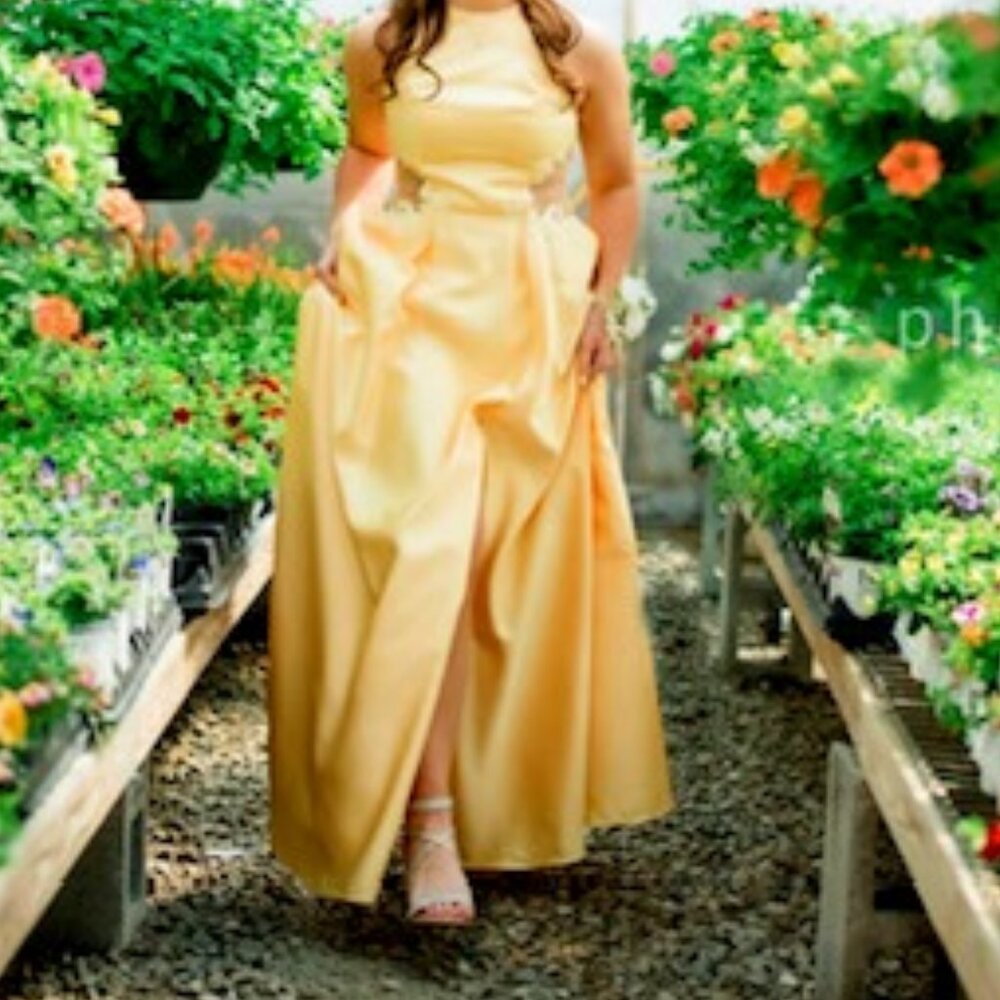 Gorgeous buttercream yellow satin prom dress with sheer lace side cutouts.